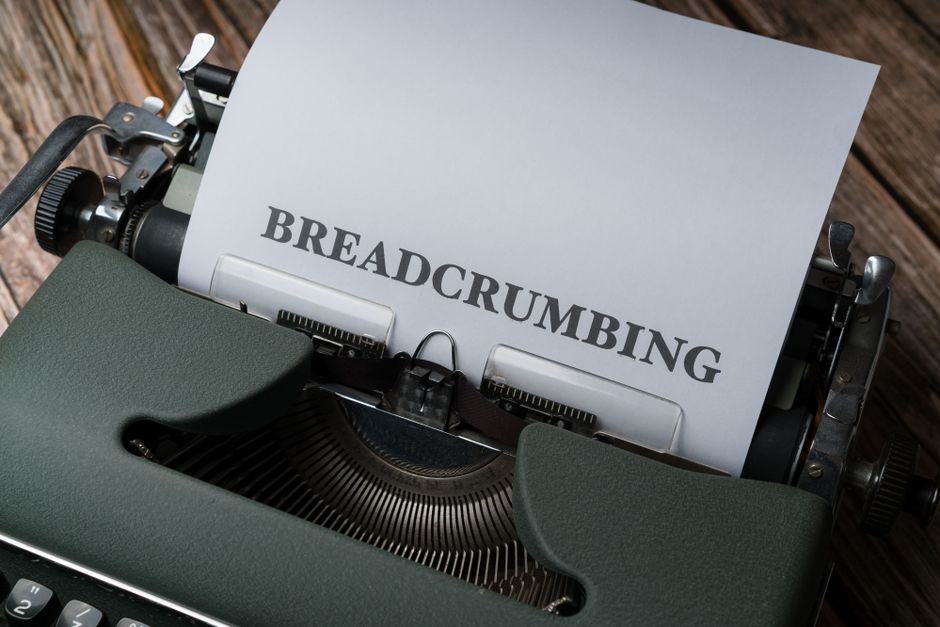 Gros plan sur une machine à écrire vintage imprimant le mot 'BREADCRUMBING' sur papier.