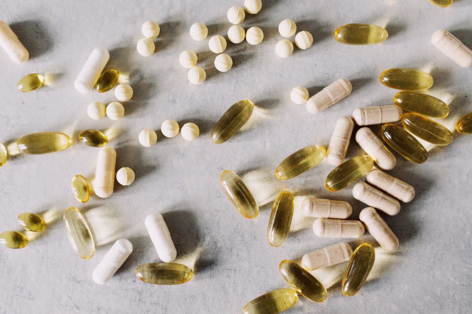 Différentes vitamines et suppléments sur un fond en marbre, capturés en style plat.